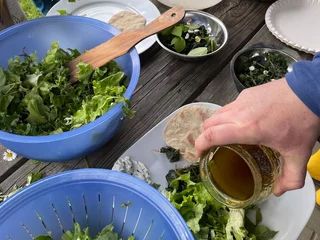 Gemeinsames Kochen mit Kräutern bei einem Teamevent in der freien Natur.